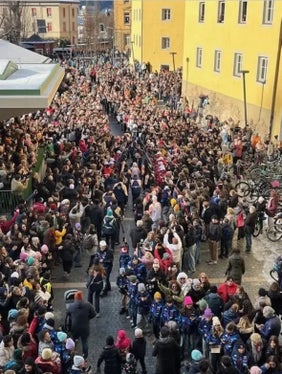 Un'immagine dall'alto di piazza Paul Tschurtschenthaler a Brunico durante l'arrivo della fiaccola olimpica. La festa nella centralissima piazza proseguirà anche durante i Giochi Olimpici Invernali di Milano Cortina. (Foto: Comune di Brunico/La foto può essere utilizzata solo nel contesto di questo comunicato) 
