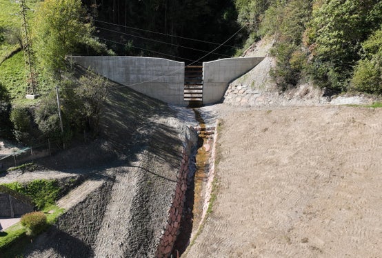 Das Landesamt für Wildbach- und Lawinenverbauung Nord hat ein Projekt im Schiedmanngraben bei Kollmann umgesetzt, um die darunterliegende Brennerstaatsstraße als wichtige Verkehrsader im Eisacktal und den Hof zu schützen. (Foto: LPA/Landesamt für Wildbach- und Lawinenverbauung Nord in der Agentur für Bevölkerungsschutz/Johannes Holzner)