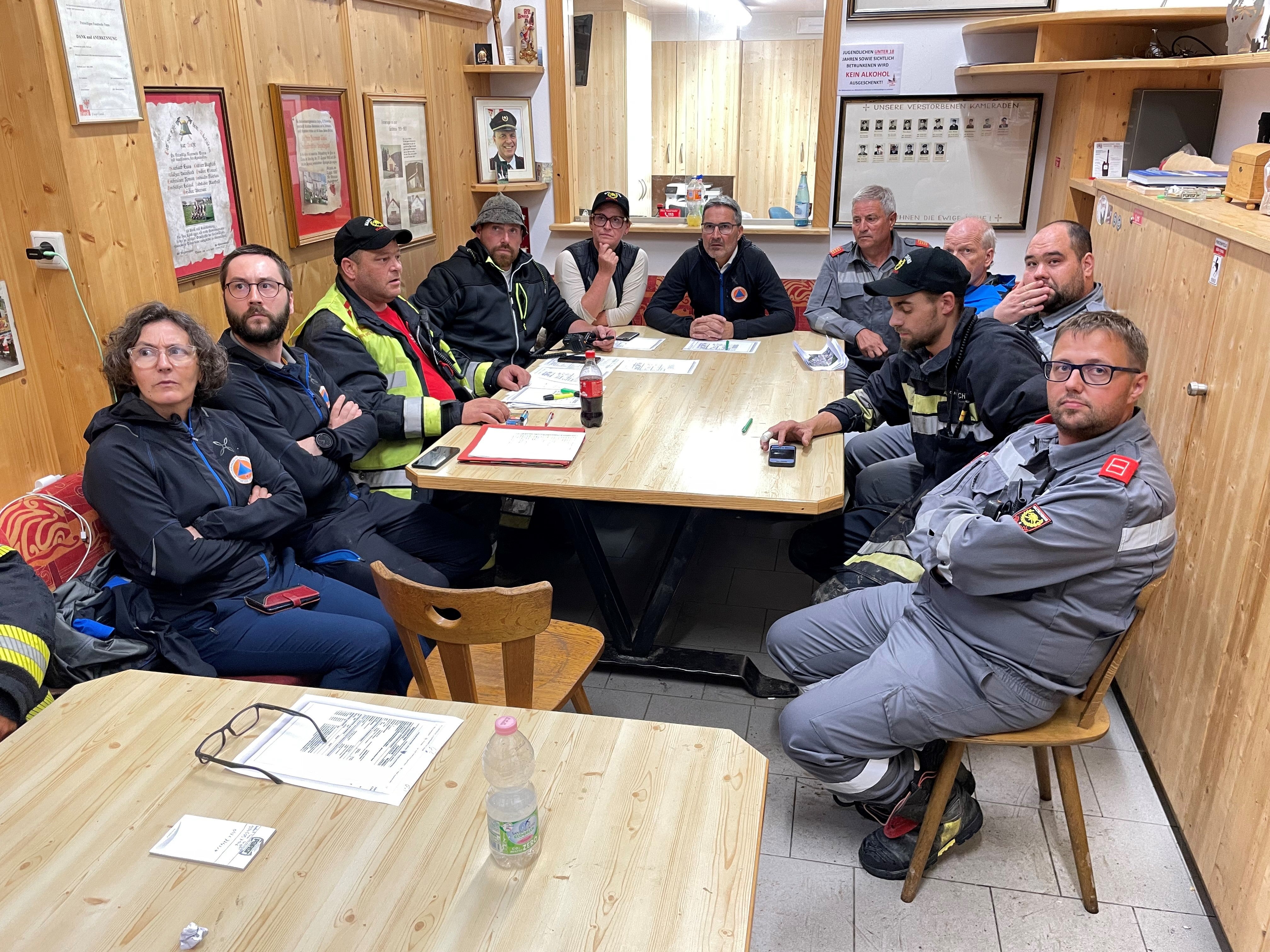 Landeshauptmann und Bevölkerungsschutzlandesrat Arno Kompatscher (im Zentrum) bei der Lagebesprechung in der Halle der Freiwilligen Feuerwehr Trens mit Vertretern der Wildbachverbauung und der Berufsfeuerwehr, der Freiwilligen Feuerwehr und der Gemeinde Freienfeld (Foto: LPA/G.News)
