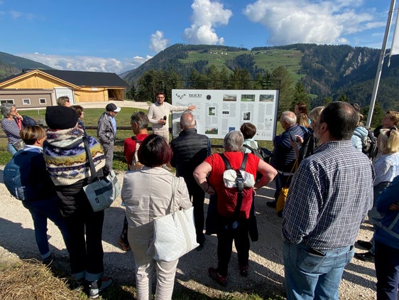 L respunsabl dl pruiet Michael Moling à n ucajion dla jita furmativa di cunsëies de furmazion de Südtirol menà tres l parch artistich Val dl’Ert, spiegan i lëures artistics metui ora, la storia de coche dut cant ie unit a s’l dé y curiusiteies dl pruiet "SMACH.Val dl’Ert". (Foto: USP/Ufize per la Furmazion Permanënta)