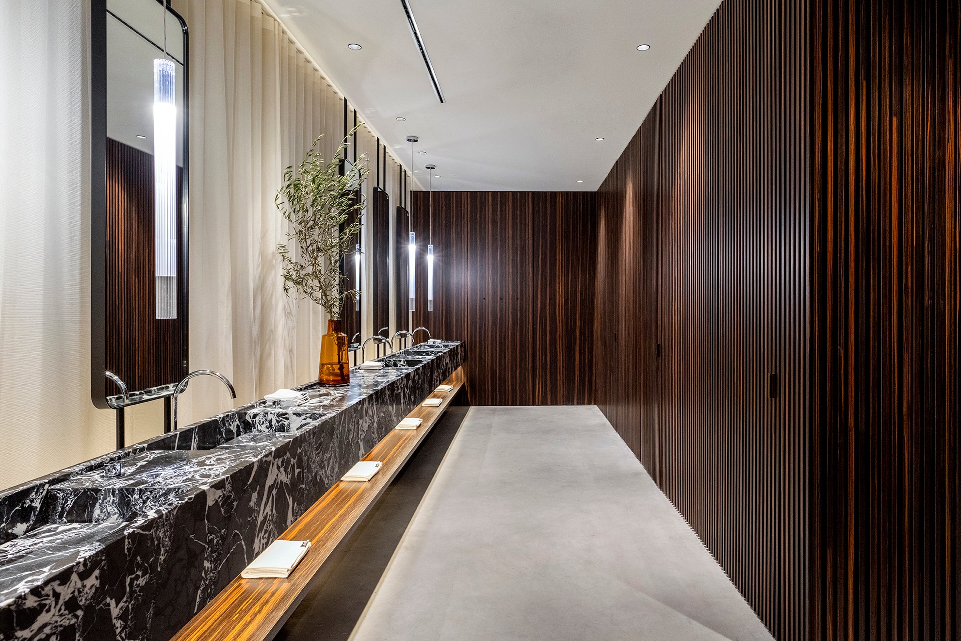 bathroom with marble sinks and wooden veneer slats