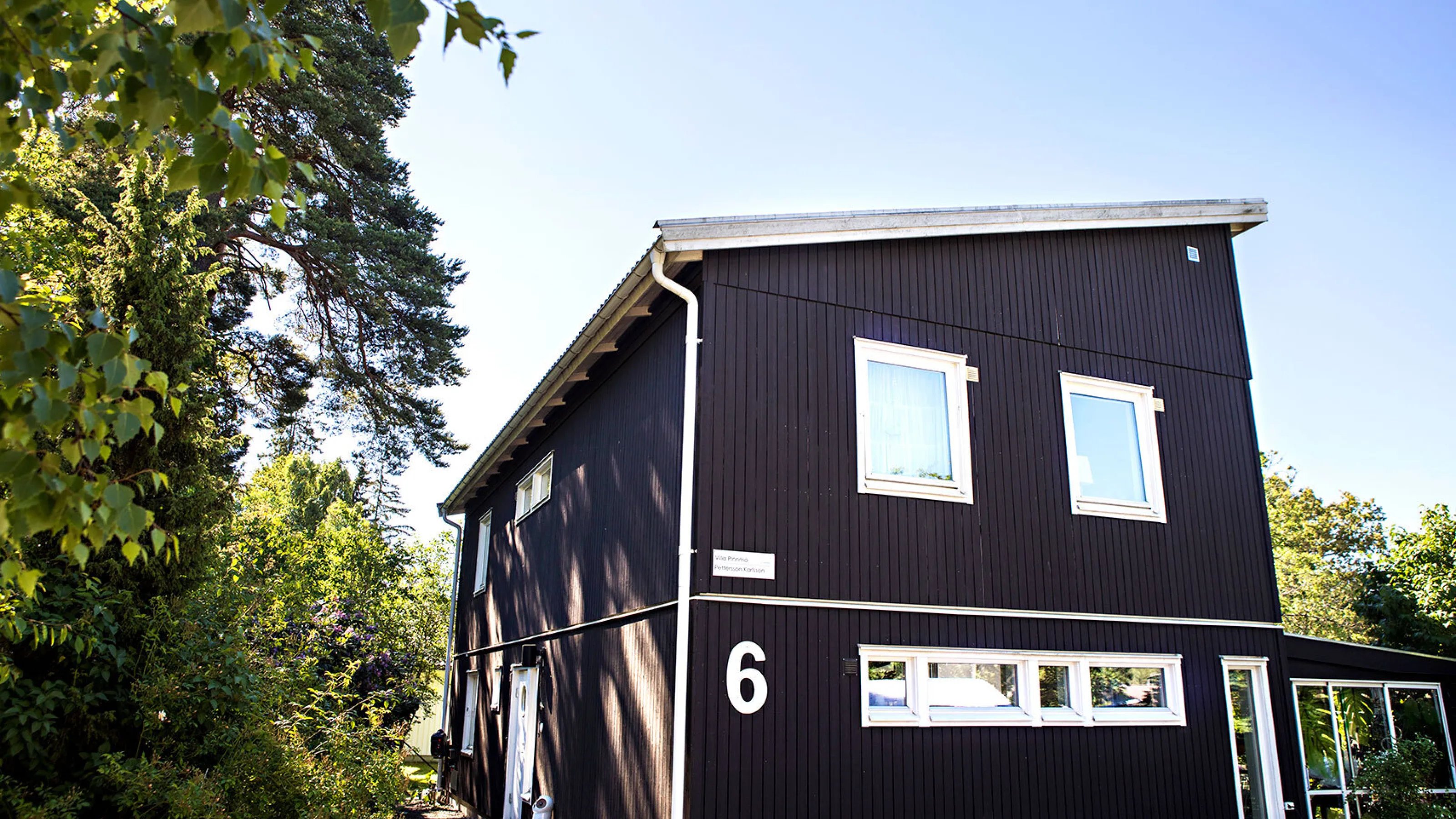 Svart trähus med stora fönster