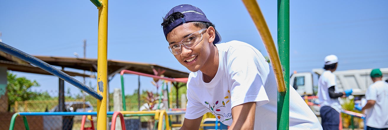 Male volunteer painting as part of Colorful Communities project