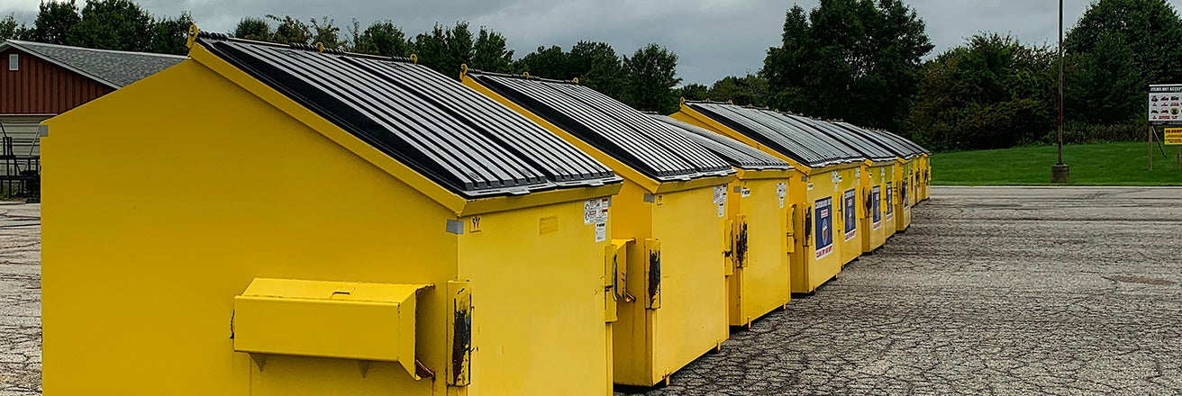 Row of waste containers with yellow coatings