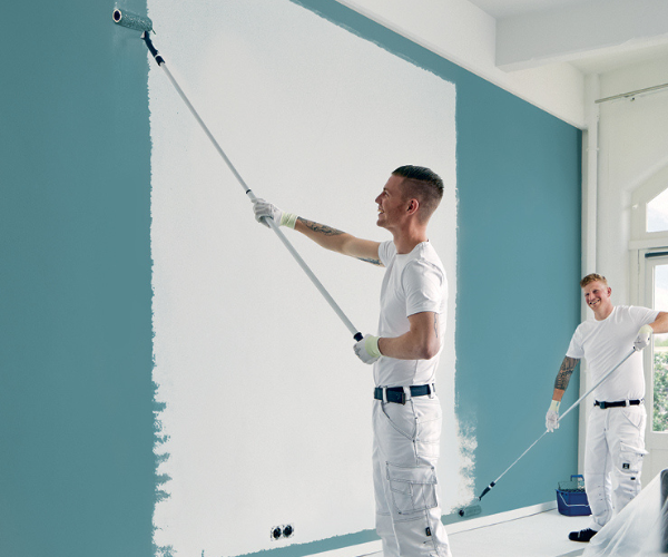 Ein paar Männer streichen eine Wand