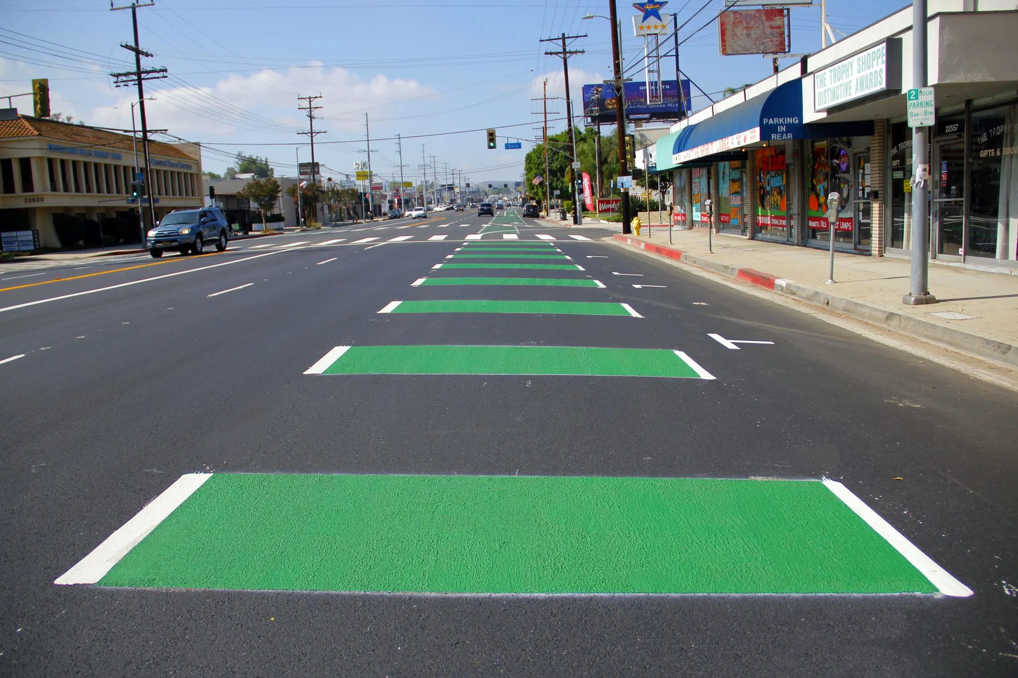 Image of a freshly painted lane on a 6-lane roadway, with large green horizontal stripes.