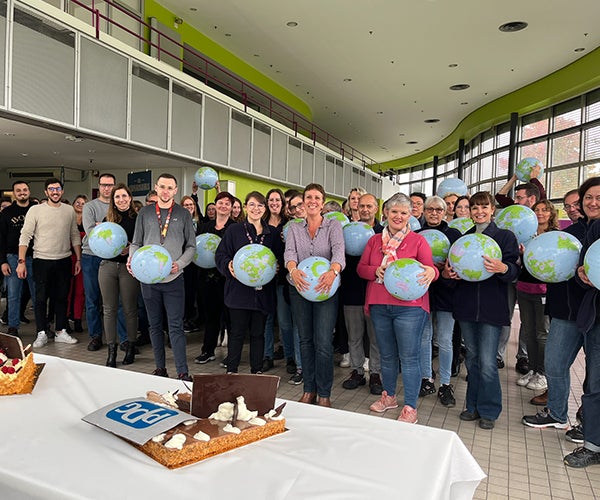 Group of PPG employees gathered holding globes