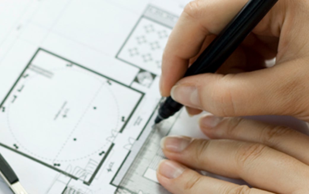 Hands writing on room layout