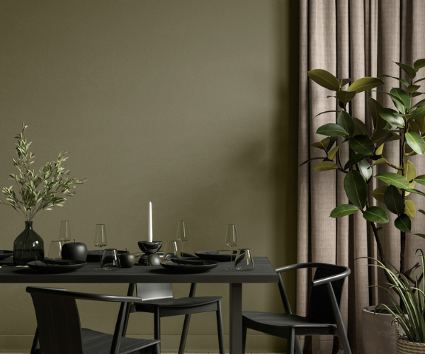 Une table avec des assiettes et des chaises dans une pièce avec une plante