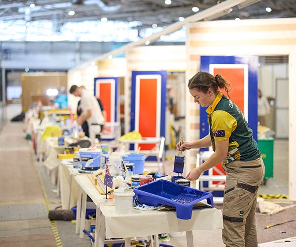 PPG employee at WorldSkills Lyon holding paint brush