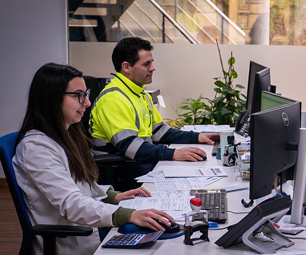 Male and female working with data on computer screens