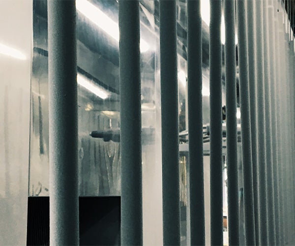 Metal pipes being sprayed with grey powder