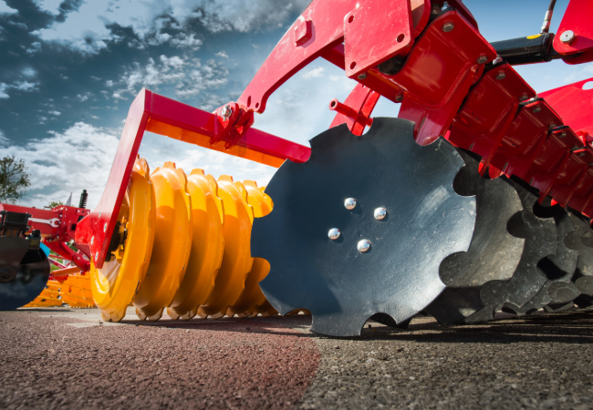 Red and yellow agricultural equipment close up of metal parts