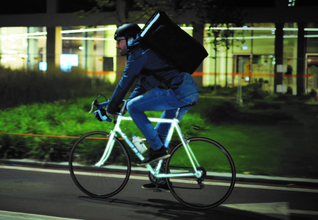 Man riding grey reflective bike at night 