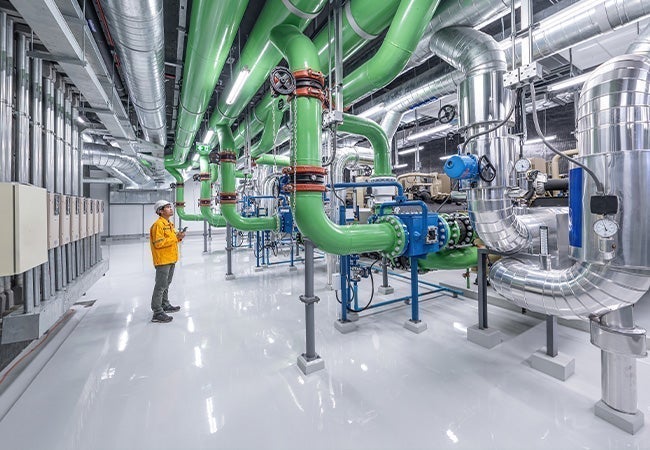A man standing in a room with green pipes