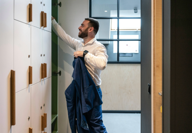 Man putting items into office locker