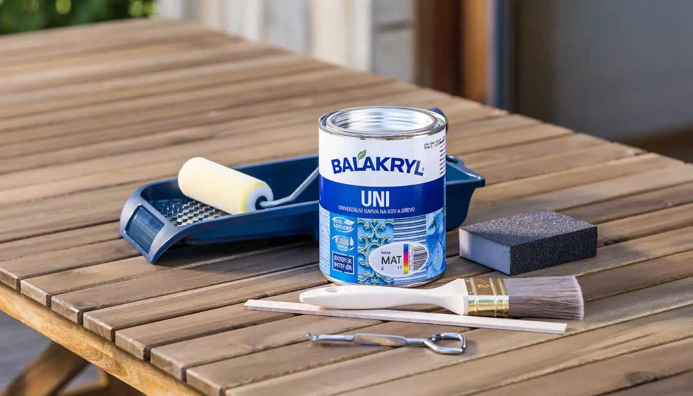 Plechovka s barvou a štětec na stole