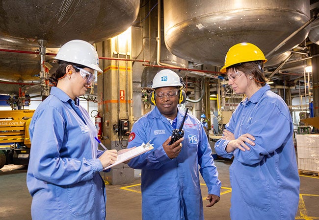 PPG workers wearing PPE next to large vessels