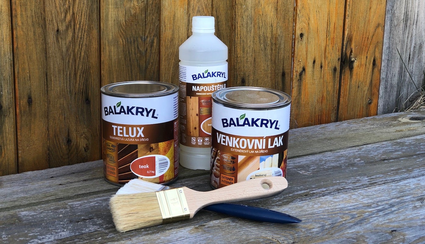 Skupina plechovek s barvou a štětec na dřevěném povrchu