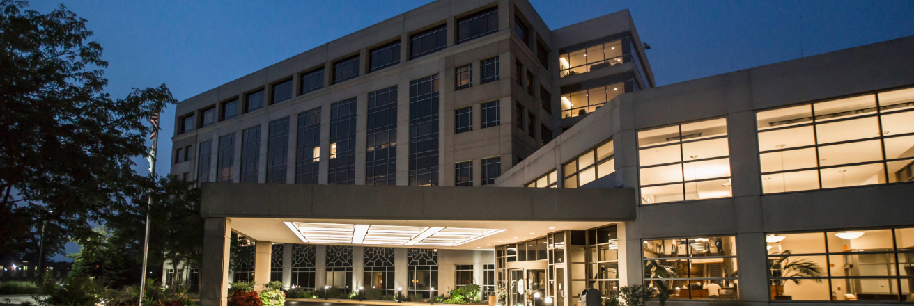Hotel building view at night focusing on the entrance, displaying well lit spaces 