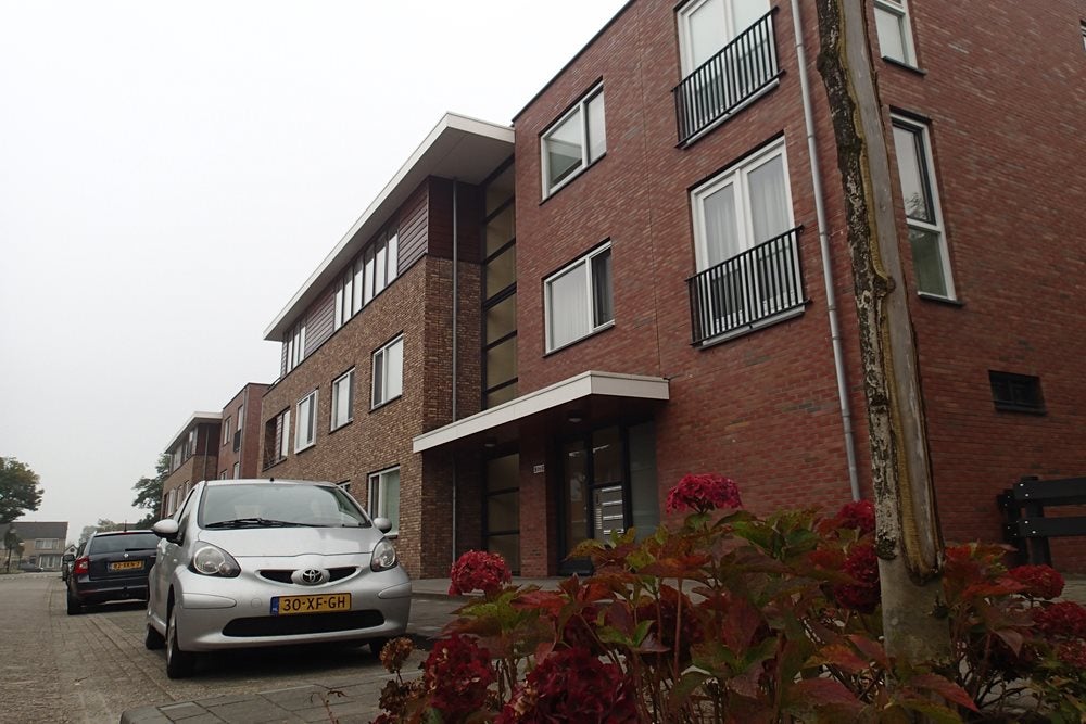 Een auto geparkeerd voor een bakstenen gebouw