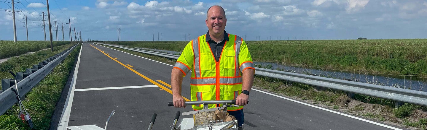 Kevin Lowe, a PPG employee within our Traffic Solutions business, poses with a road-marking equipment