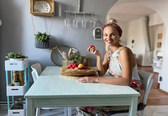 Žena sedící u stolu s miskou ovoce