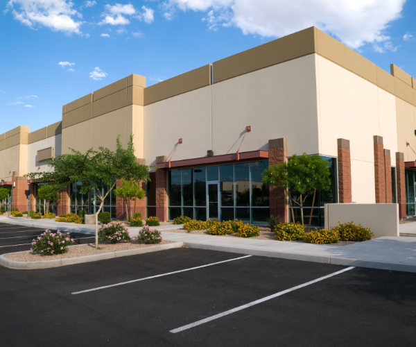 Large storefront painted in cream and brown on an empty parking lot