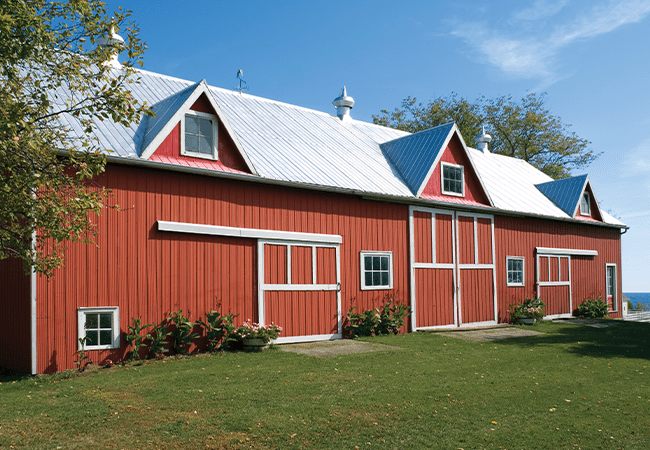 Red coil building with white roof set against blue water and sky