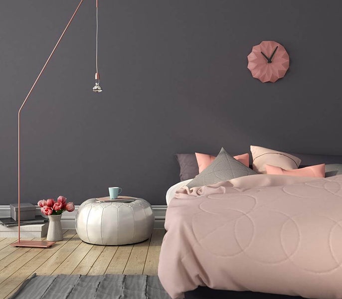 A bedroom with a pink bed and a pink clock