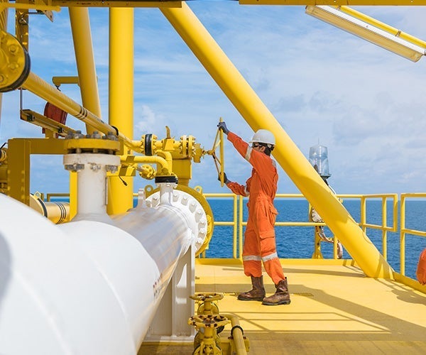 A man in orange jumpsuit on a yellow platform