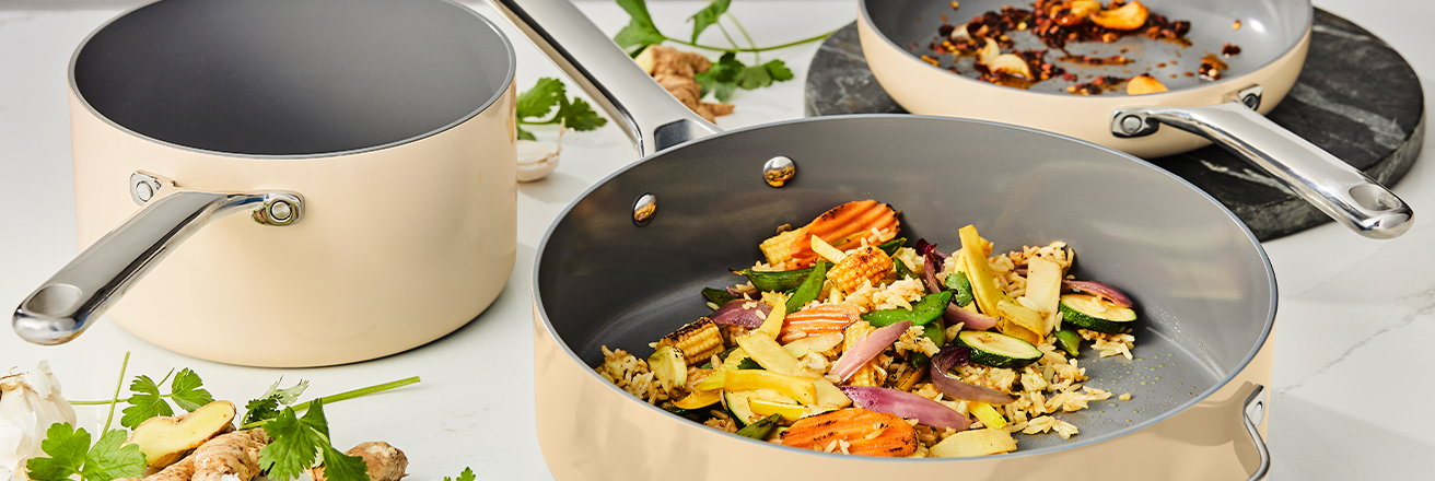 Consumer product image showing a sol-gel ceramic pan set with cream exterior and gray interior coating