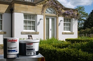A house with Leyland paint cans in front of it