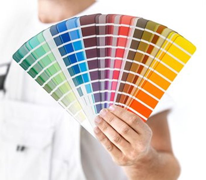 A person holding a fan of color swatches