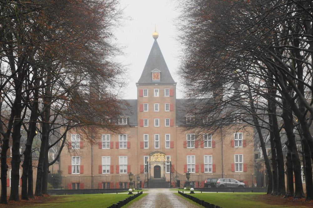 Een gebouw met een poort en bomen
