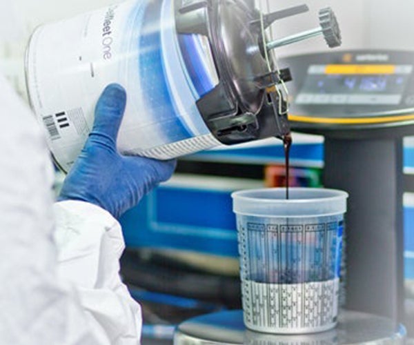 Pouring paint into a measuring cup on scale