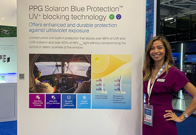 Barbara Flocchini, a PPG employee from our Aerospace business, next to the PPG Solaron Blue Protection technology display