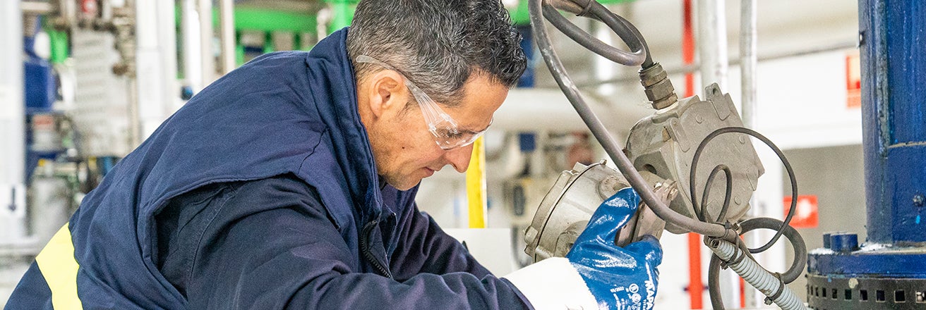 Male worker within factory using machinery