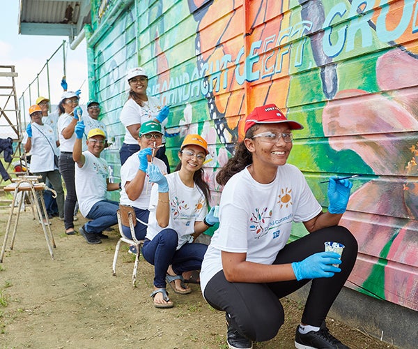 PPG volunteers painting colorful mural for Colorful Communities
