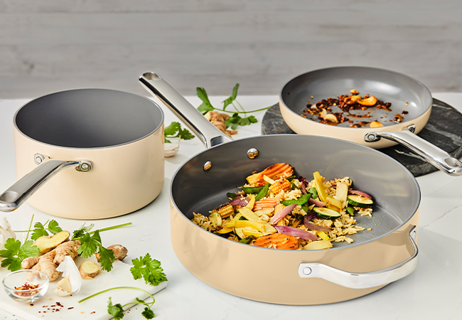 Consumer product image showing a sol-gel ceramic pan set with cream exterior and gray interior coating