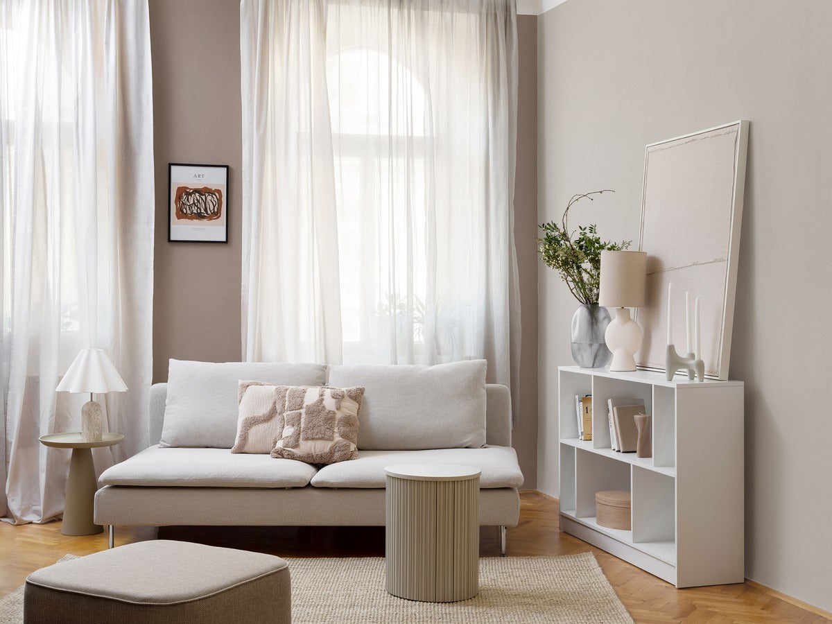 Obývací pokoj s pohovkou a bílou knihovnou