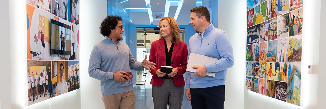Three colleagues walking and chatting at PPG