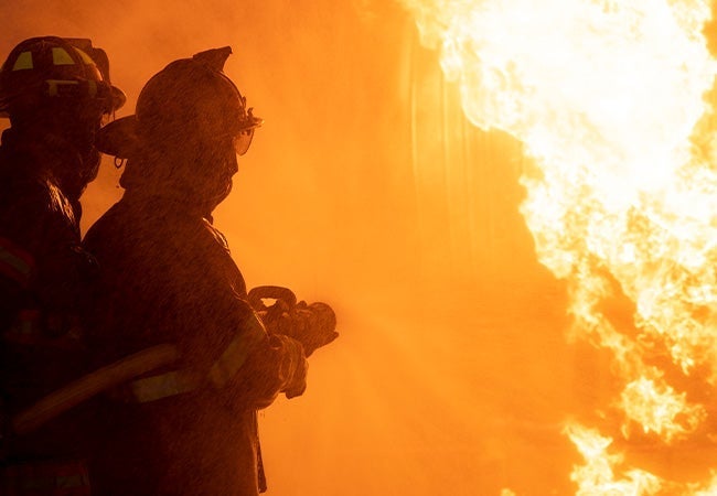 Two firefighters fighting blaze.