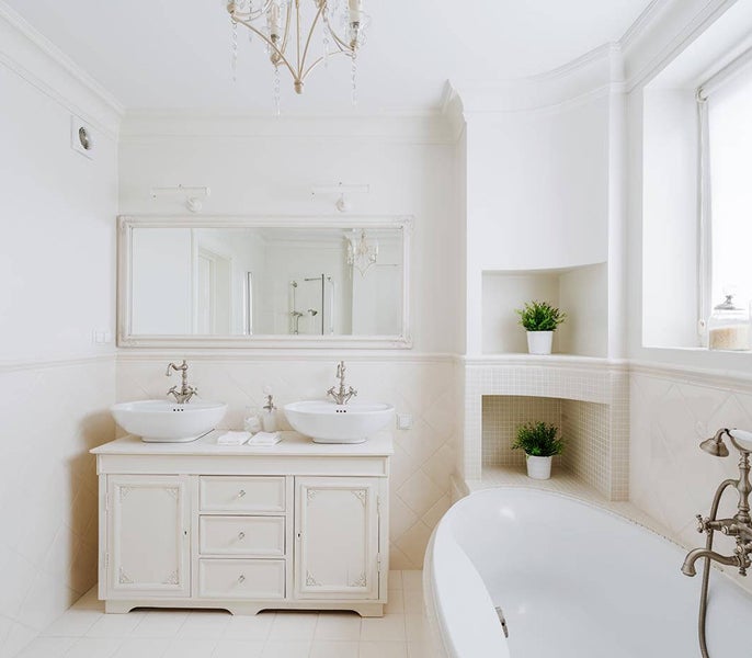 A bathroom with white walls and a large mirror