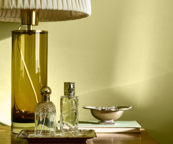 Une table avec une lampe et des flacons de parfum