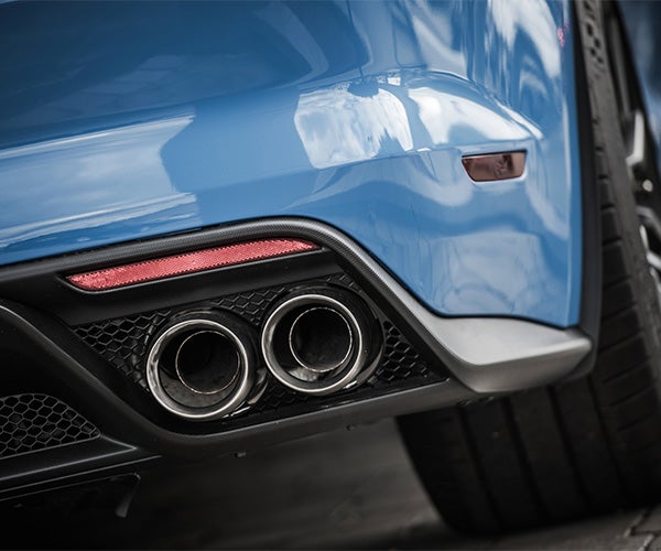 Back of a blue car with a close view of two mufflers
