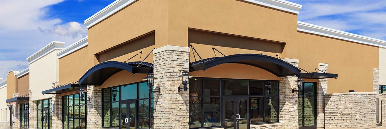 Retail street with corner facing store, brick walls and a beige finish