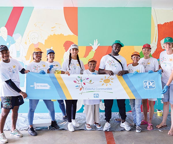 Group of volunteers at PPG's Colorful Communities next to colorful mural