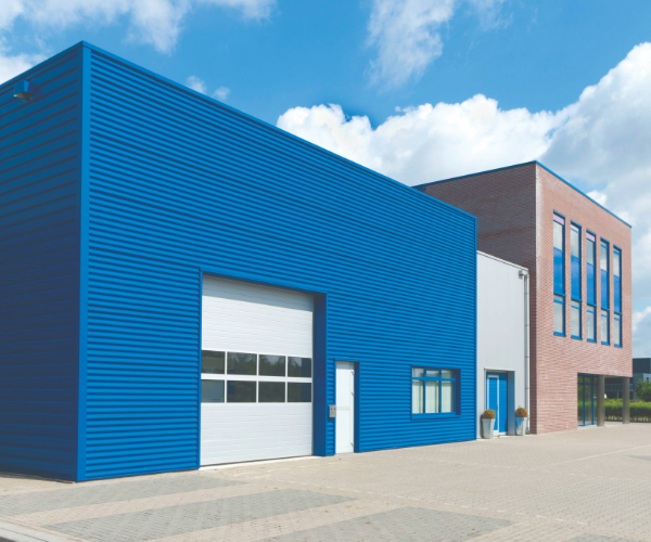 Blue coil building with white shutters connected to a brick office building