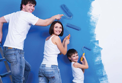 Family painting a wall with blue paint